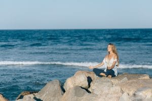 Woman Meditating by the Ocean